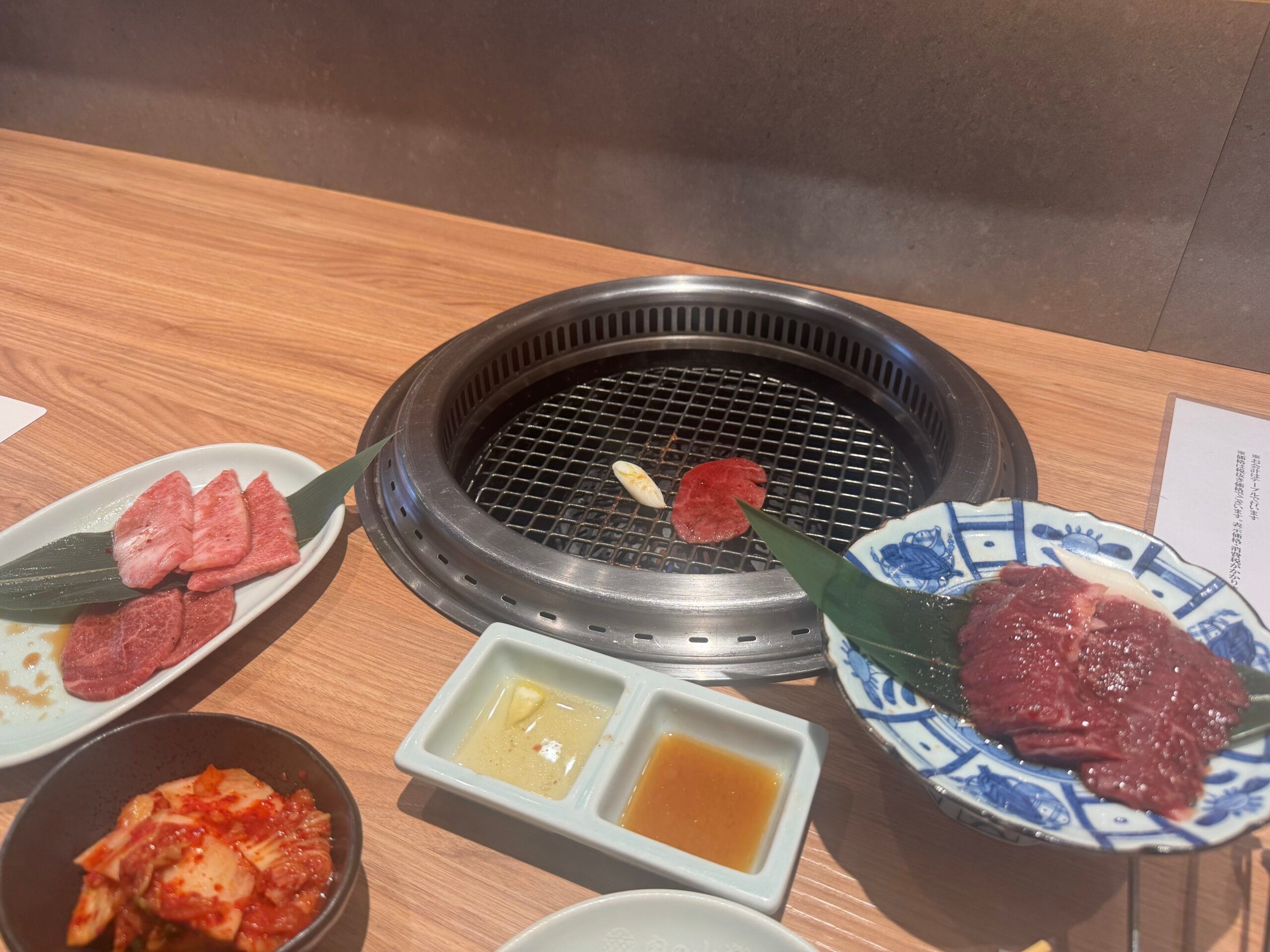 1인용 화로에 고기를 굽는 모습과 옆에 놓인 김치